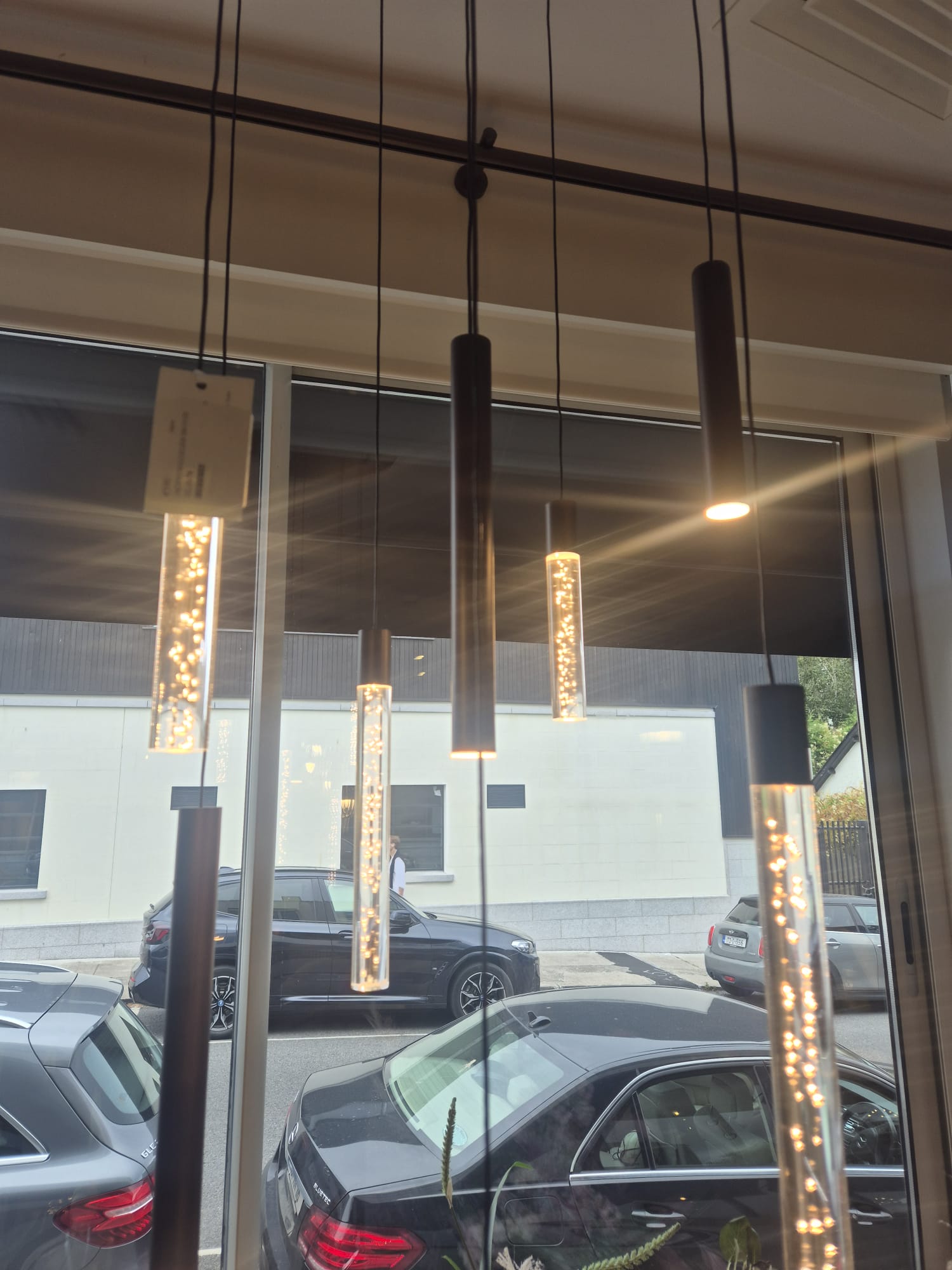 Row of slim pendants set out and fitted over a display.