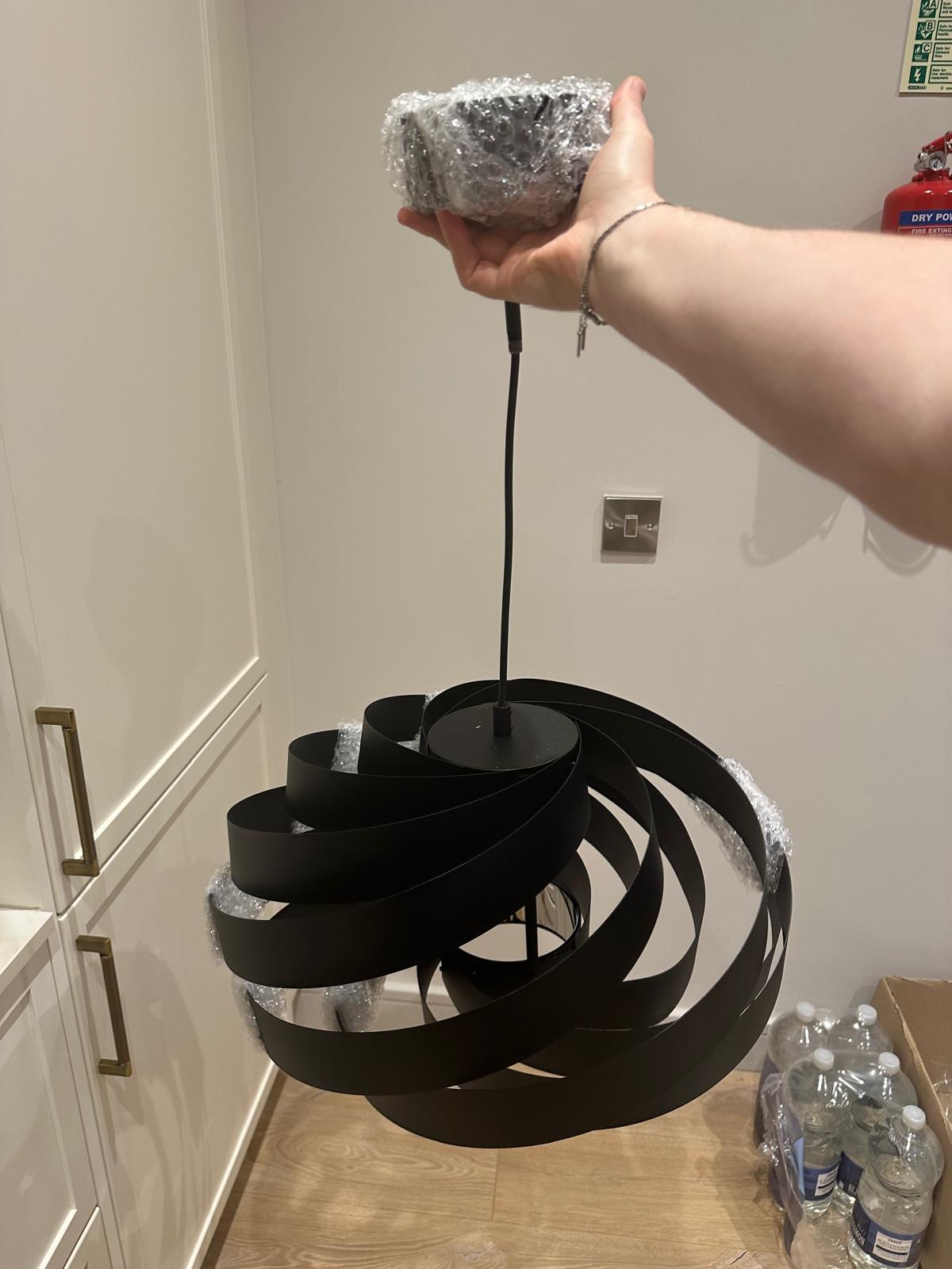 Spiral black pendant unwrapped and made ready to hang.