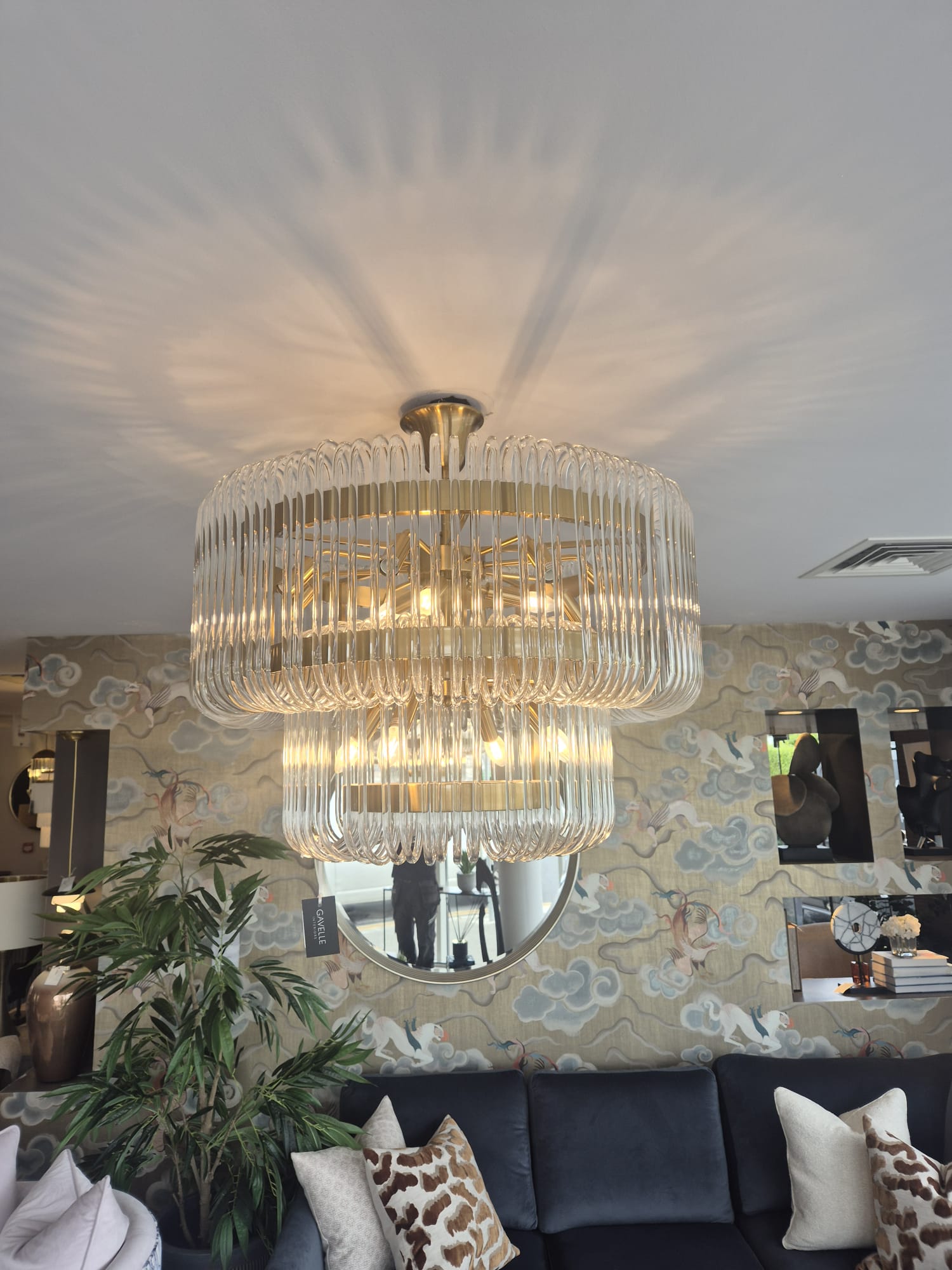 Tiered glass chandelier installed and balanced on a ceiling fixing.